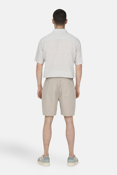 Short beige de ONLY & SONS, avec une ceinture élastique et un poche arrière.
