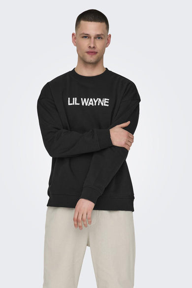 Zwarte sweater met ronde hals van ONLY & SONS, met "LIL WAYNE" erop, gecombineerd met beige broek.