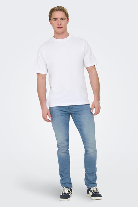 Lichtblauwe denim slim jeans van ONLY & SONS®, gedragen met een wit T-shirt en zwarte sneakers.