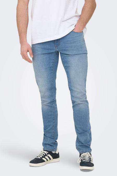 Lichtblauwe slim jeans van ONLY & SONS®, gedragen met een wit T-shirt en donkere sneakers met witte strepen.
