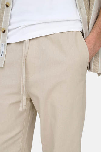 Pantalon écru de ONLY & SONS, avec cordon et une main dans la poche.