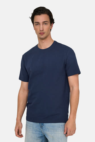 T-shirt bleu à manches courtes de ONLY & SONS, avec texture et porté avec un pantalon de cuir.