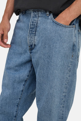 Jean tapered bleu clair de ONLY & SONS®, avec la main dans la poche et texture denim classique.