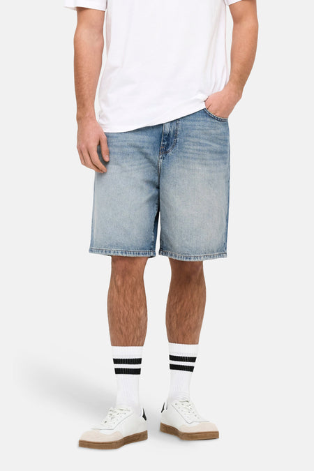 Jeansshort van mid blue denim, van ONLY & SONS, met witte sokken en witte sneakers.
