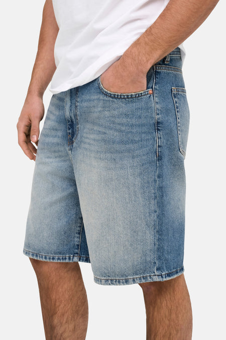 Short en jean ONLY & SONS® en denim bleu moyen, avec main dans la poche et coupe courte.