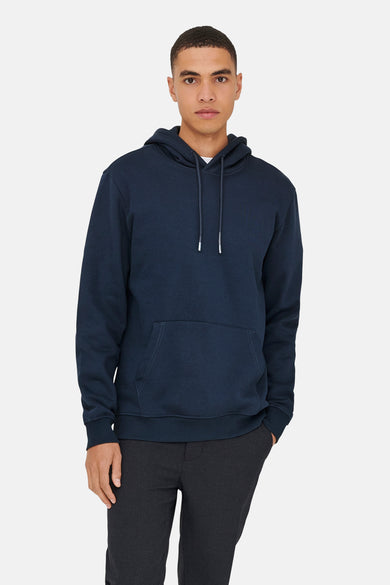 Blauwe sweater met kap van ONLY & SONS, met trekkoorden en een kangoeroezak, gedragen met een donkere broek.
