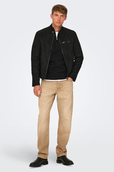 Zwarte korte jas van ONLY & SONS®, gedragen over een zwarte trui en een wit T-shirt, gecombineerd met bruine jeans en zwarte schoenen.