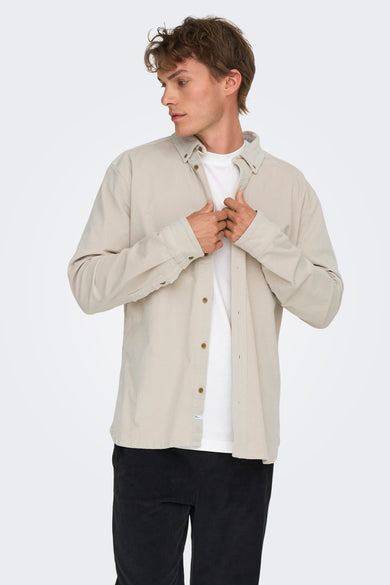 Ecrukleurig overhemd met lange mouwen van ONLY & SONS, met knoopsluiting, gedragen over een wit T-shirt en een zwarte broek.