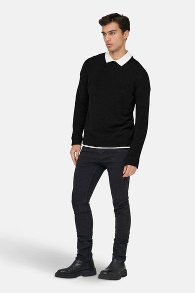 Zwarte trui met ronde hals van ONLY & SONS®, gestyled met een wit overhemd en donkere jeans.