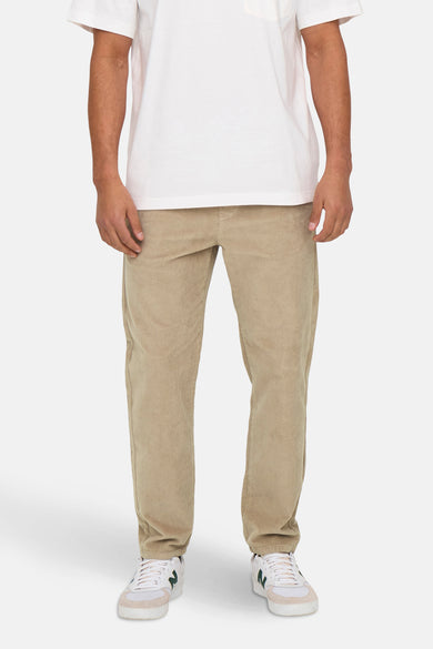 Beige broek van ONLY & SONS® met een corduroy textuur en witte sneakers.
