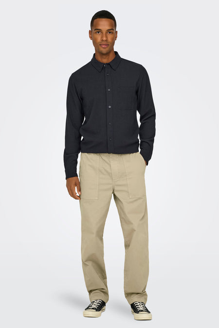 Beige broek van ONLY & SONS®, met steekzakken en cargo-zakken, gecombineerd met een zwart overhemd en sneakers.
