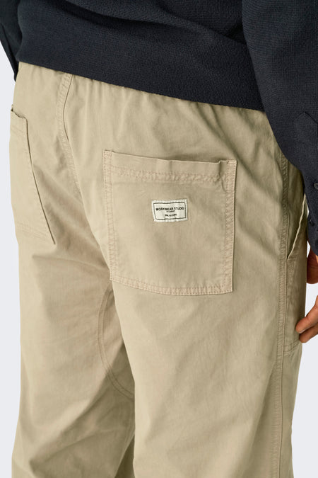 Beige broek van ONLY & SONS, met opgestikte zak en merklabel, onderdeel van een donkerblauwe outfit.
