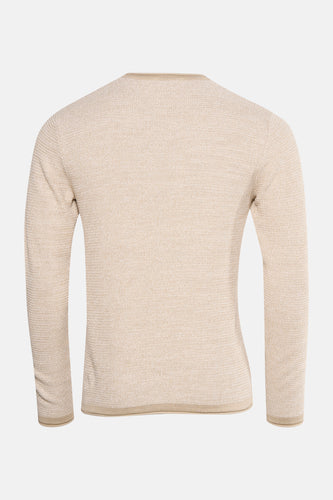 Beige gebreide trui met lange mouwen.
