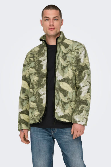 Multikleurige fleece van ONLY & SONS, met een bladerenpatroon en een zwarte rits, gedragen met een zwart shirt en blauwe jeans.
