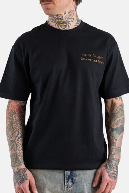 T-shirt noir à manches courtes ONLY & SONS®, avec imprimé jaune et tatouages visibles.