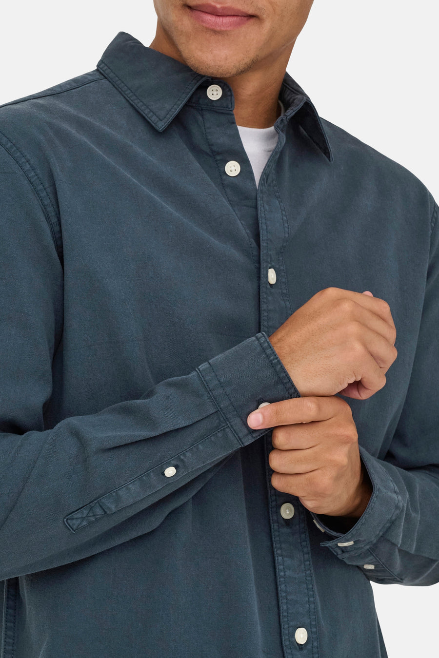 Blauw hemd met lange mouwen, witte knopen.