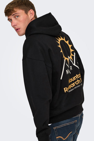 Zwarte sweater met kap van ONLY & SONS, met rugprint en gedragen met een donkere jeans.
