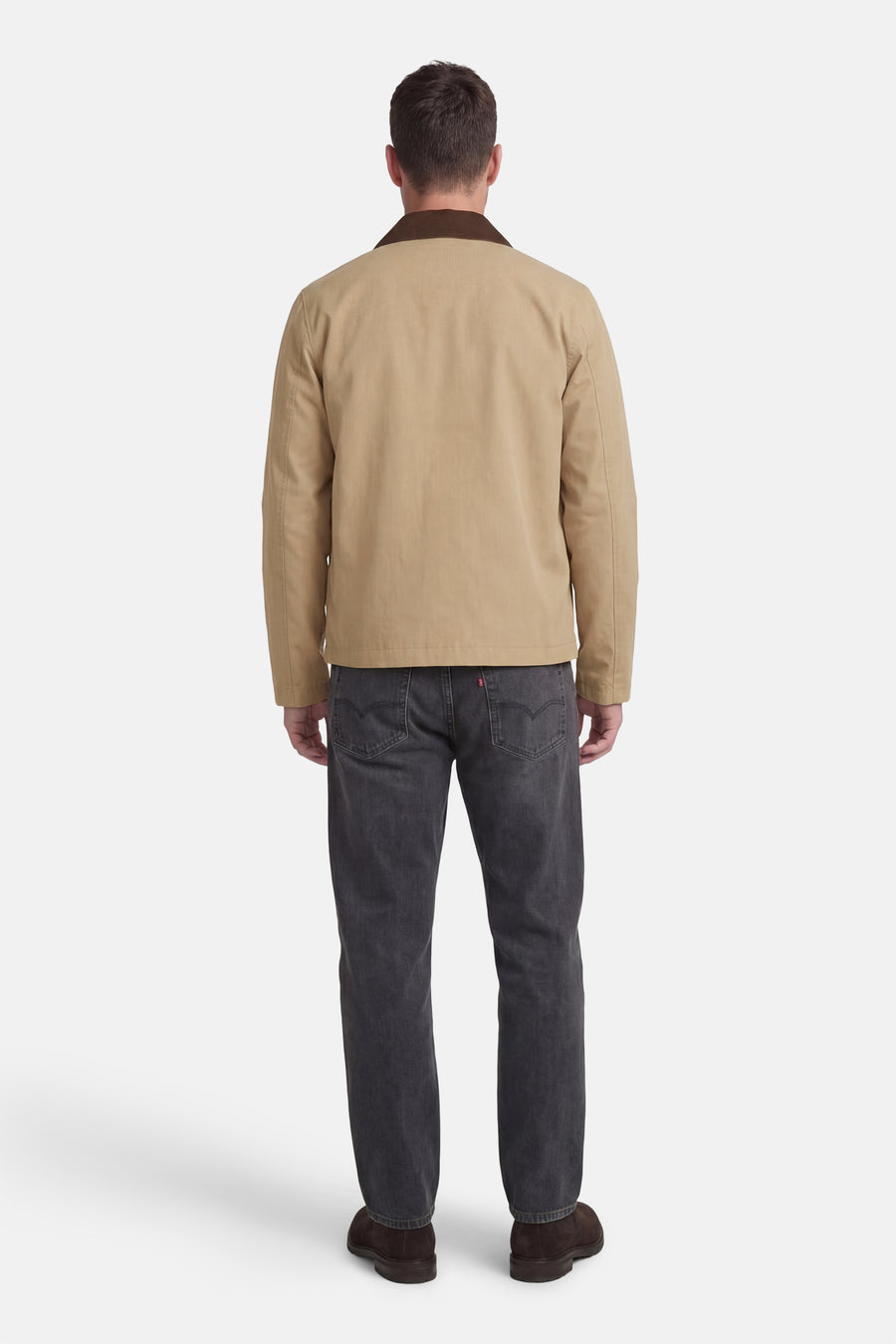 Beige korte jas van ONLY & SONS®, met bruine kraag, gecombineerd met grijze jeans en bruine schoenen, van achteren gezien.