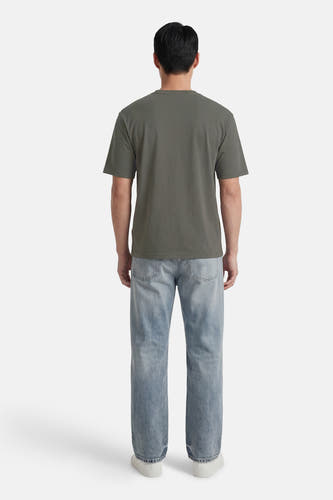 Groen T-shirt met korte mouwen van ONLY & SONS®, gezien vanaf de achterkant, met jeans en witte sneakers.