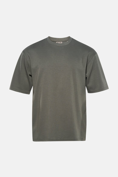 T-shirt vert à manches courtes ONLY & SONS®, porté avec un jean bleu et des baskets blanches.