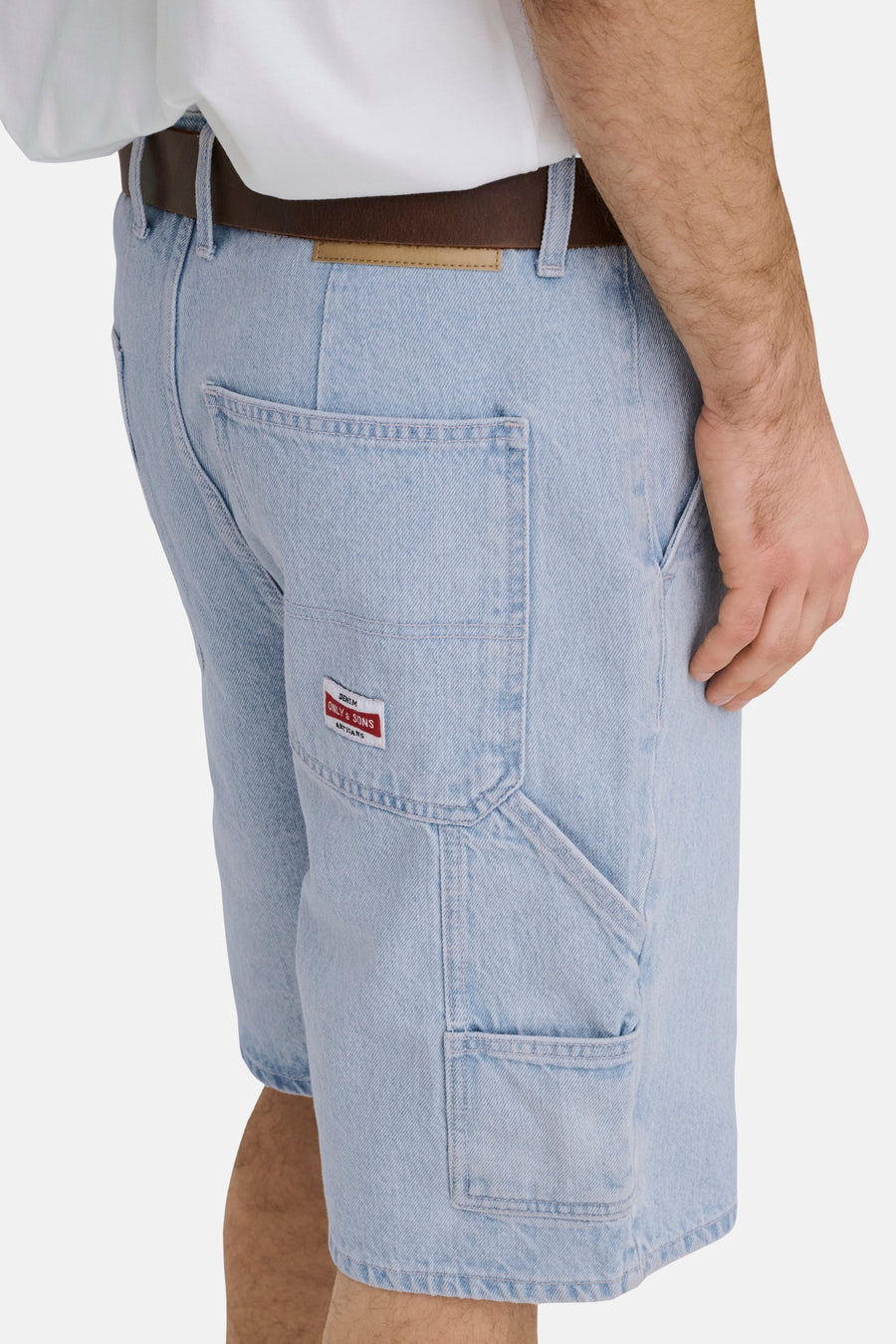 Short en jean bleu clair ONLY & SONS® avec détails de charpentier, une ceinture marron foncé et un t-shirt blanc, vue de profil.