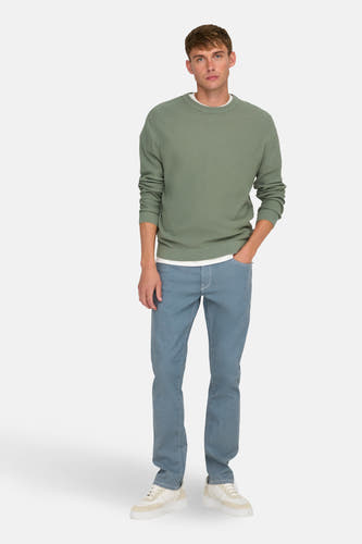 Groene trui met ronde hals van ONLY & SONS, gedragen met een wit T-shirt en blauwe jeans met witte sneakers.