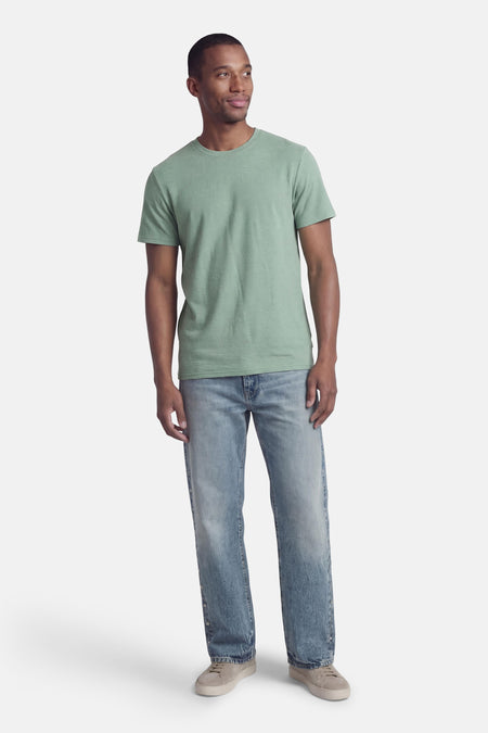 Groen T-shirt met korte mouwen van ONLY & SONS®, gedragen met blauwe jeans en grijze schoenen.
