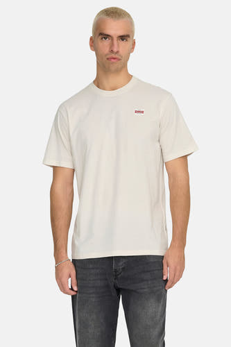 T-shirt écru à manches courtes de ONLY & SONS, avec un petit logo sur la poitrine, associé à un jean et des baskets.