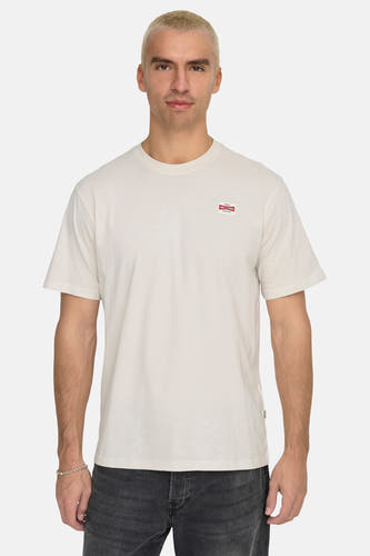 T-shirt écru à manches courtes de ONLY & SONS, avec petit logo sur la poitrine et jeans gris.