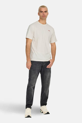 T-shirt écru à manches courtes de ONLY & SONS, porté avec des jeans gris et des baskets blanches.