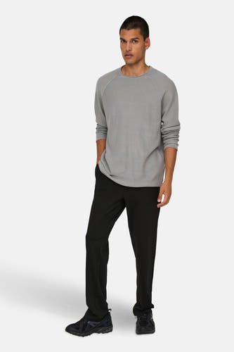 Zwarte broek van ONLY & SONS®, gecombineerd met een grijs shirt en zwarte sneakers.
