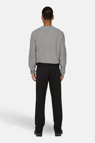 Zwarte broek van ONLY & SONS®, gezien vanaf de achterkant, gecombineerd met een grijs shirt en schoenen.
