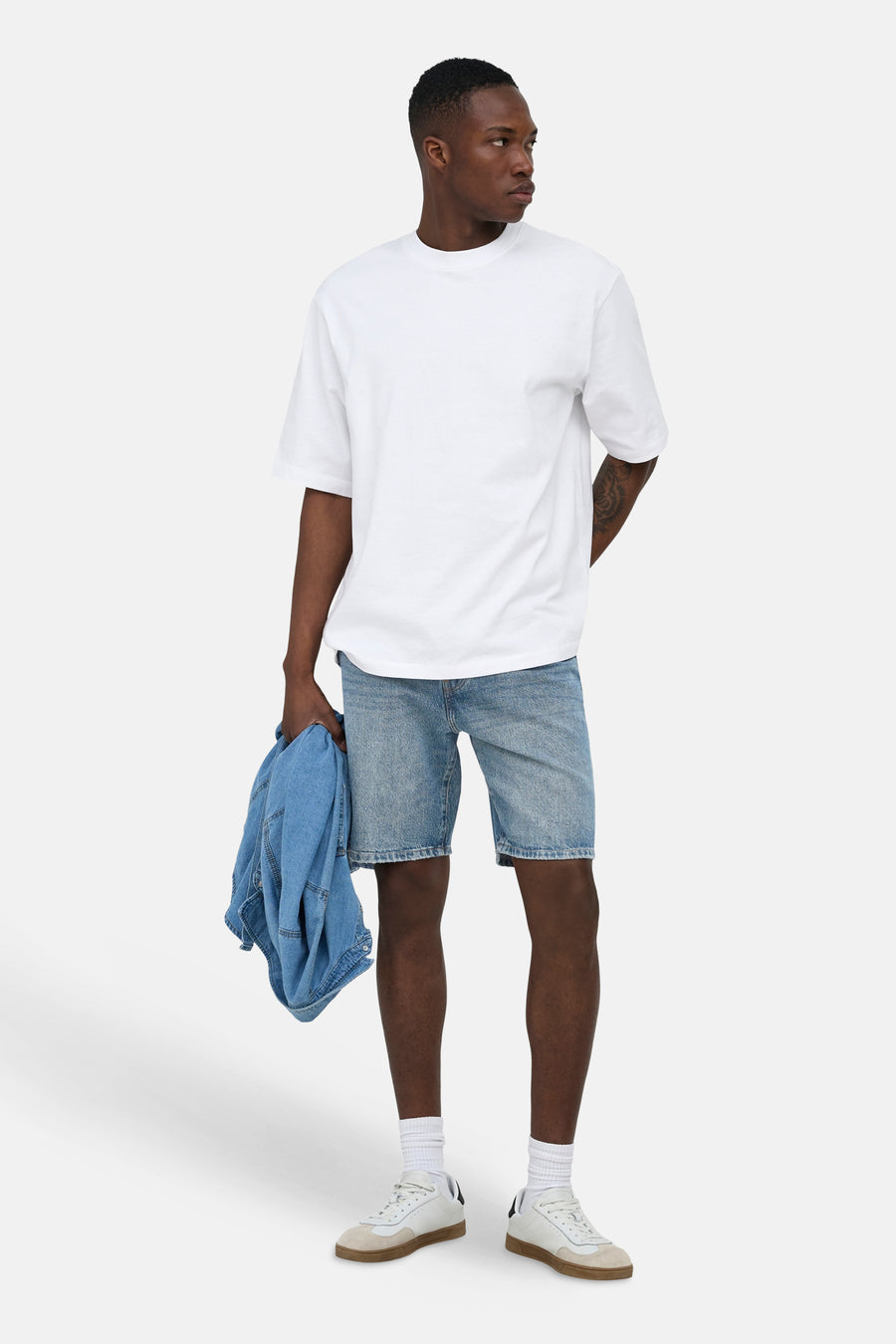 Middenblauwe spijkerjeansshort van ONLY & SONS®, knie-lengte, gedragen door een man met wit T-shirt en witte sneakers.