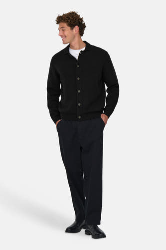 Zwart vest van ONLY & SONS® met knoopsluiting, gedragen over een wit T-shirt en donkere broek.