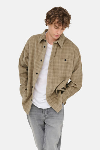 Beige overhemd met lange mouwen van ONLY & SONS®, met ruitpatroon, gedragen over een wit T-shirt en grijze jeans.
