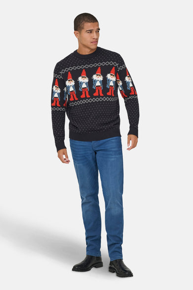 Blauwe trui met ronde hals van ONLY & SONS, met kerstkabouters en stippen, gecombineerd met jeans en zwarte schoenen.
