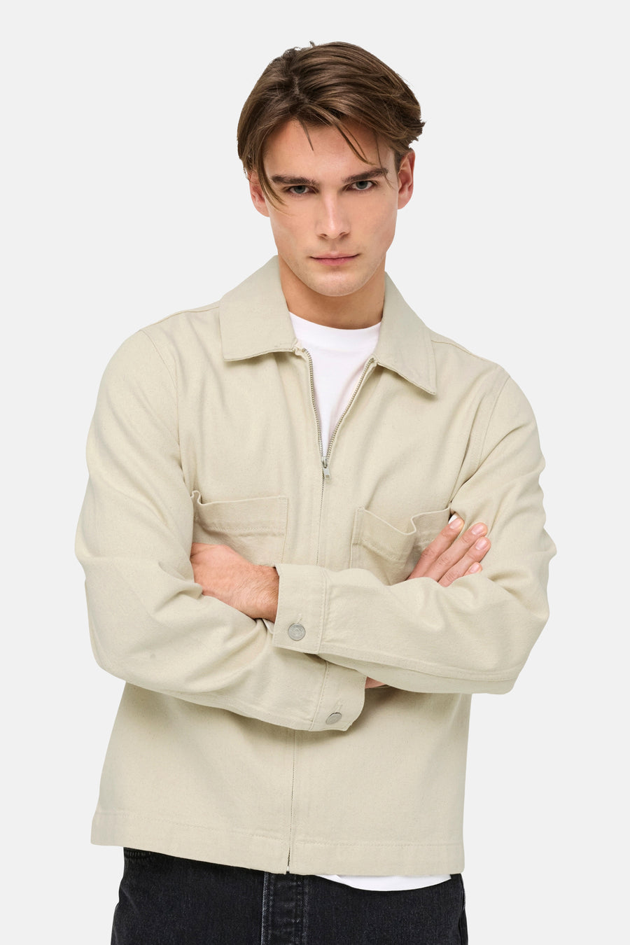 Ecru jeansjas van ONLY & SONS®, met lange mouwen en een ritssluiting, gedragen over een wit T-shirt.
