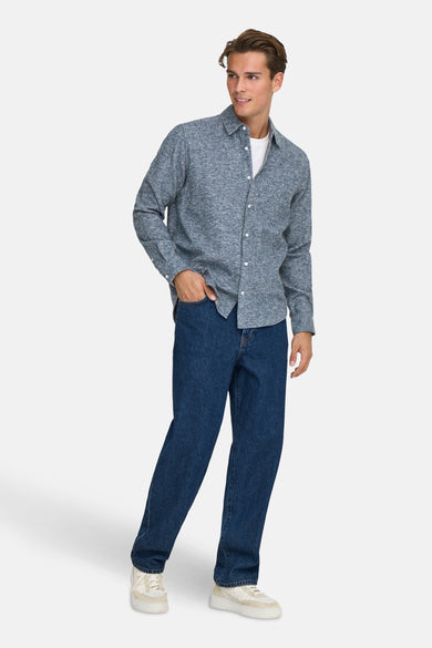 Chemise bleue à manches longues de ONLY & SONS, avec col boutonné, associée à des jeans et des baskets blanches.