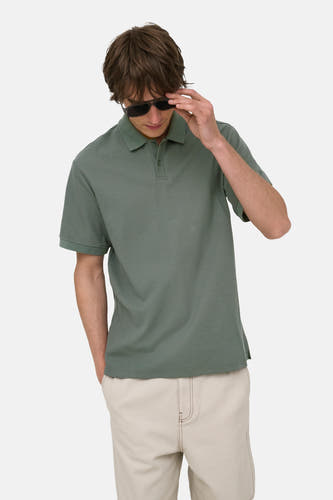 Groene polo van ONLY & SONS® met korte mouwen en piqué textuur, gedragen door model met zonnebril en beige broek, front view