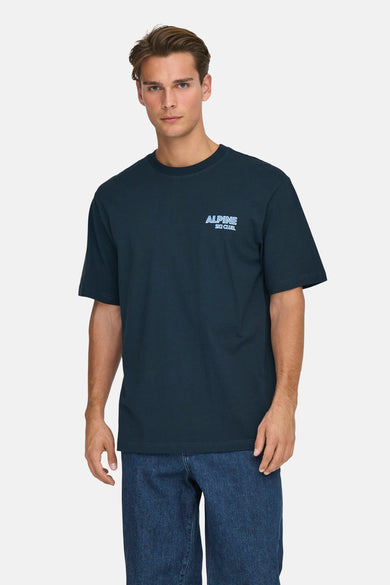 T-shirt bleu à manches courtes de ONLY & SONS, porté avec des jeans et des baskets blanches.
