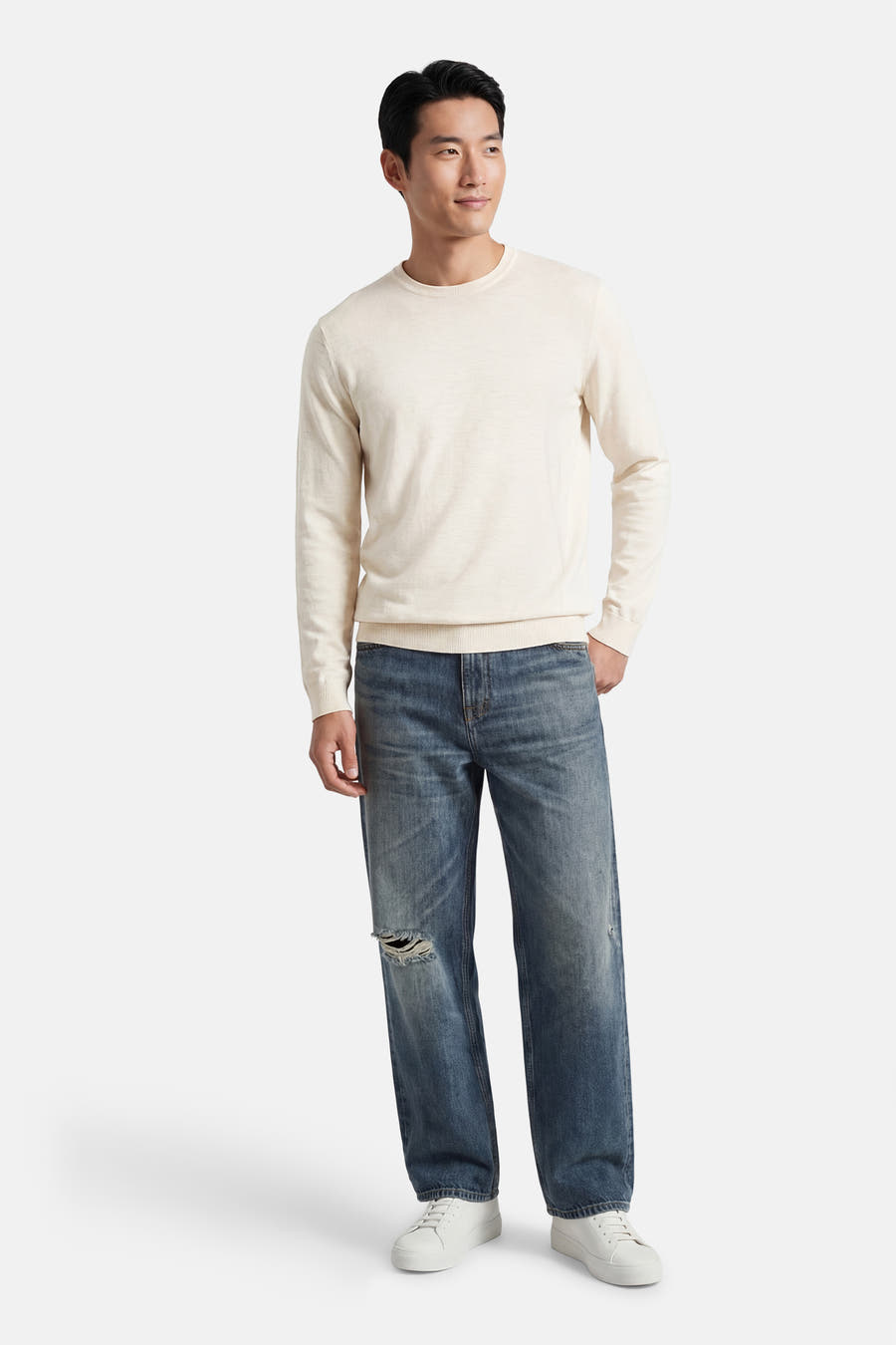 Ecru pull met ronde hals van ONLY & SONS®, gedragen met een blauwe jeans met scheuren en witte sneakers.