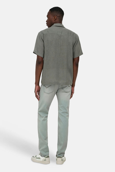 Chemise kaki à manches courtes ONLY & SONS®, en tissu texturé, portée par un homme de dos, associée à un jean et des baskets.