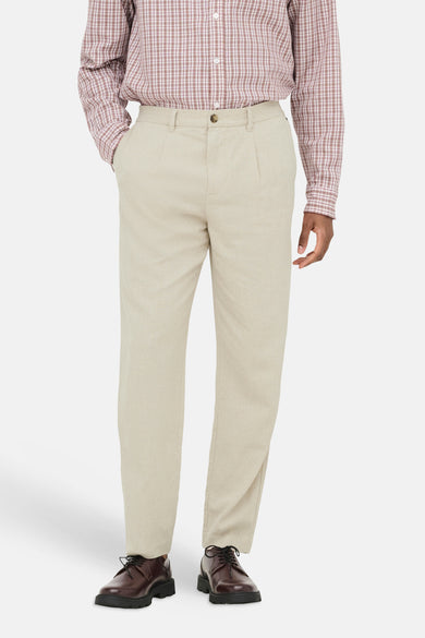 Beige broek van ONLY & SONS® met plooien en wijde pijpen, gedragen met een geruit overhemd en bruine schoenen.