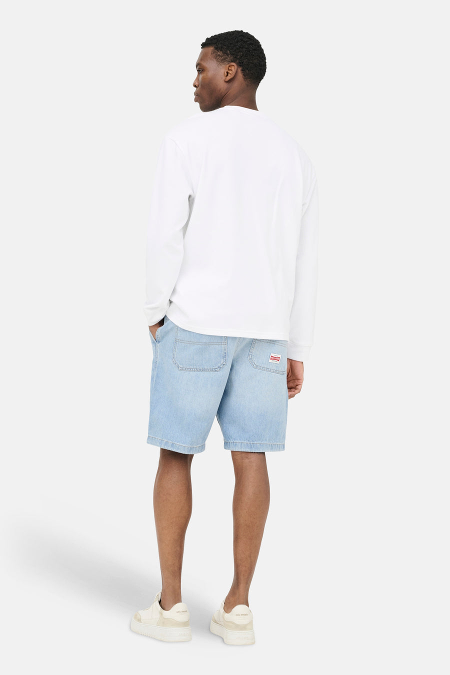 Short en jean en denim bleu clair de ONLY & SONS, avec poches arrière et une étiquette rouge.