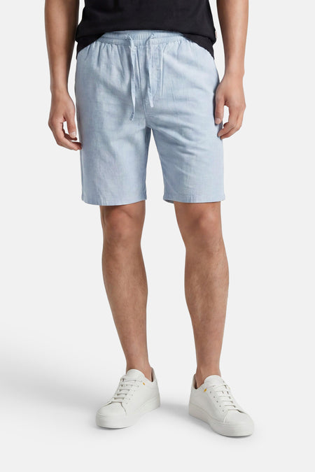 Lichtblauwe short van ONLY & SONS® met elastische tailleband en trekkoord, gedragen met een zwart t-shirt en witte sneakers.