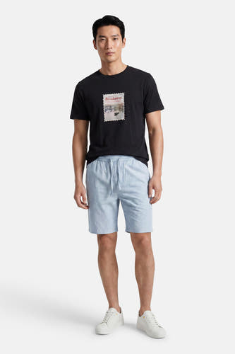 Lichtblauwe short van ONLY & SONS® met trekkoord, gedragen door een man met een zwart T-shirt en witte sneakers.