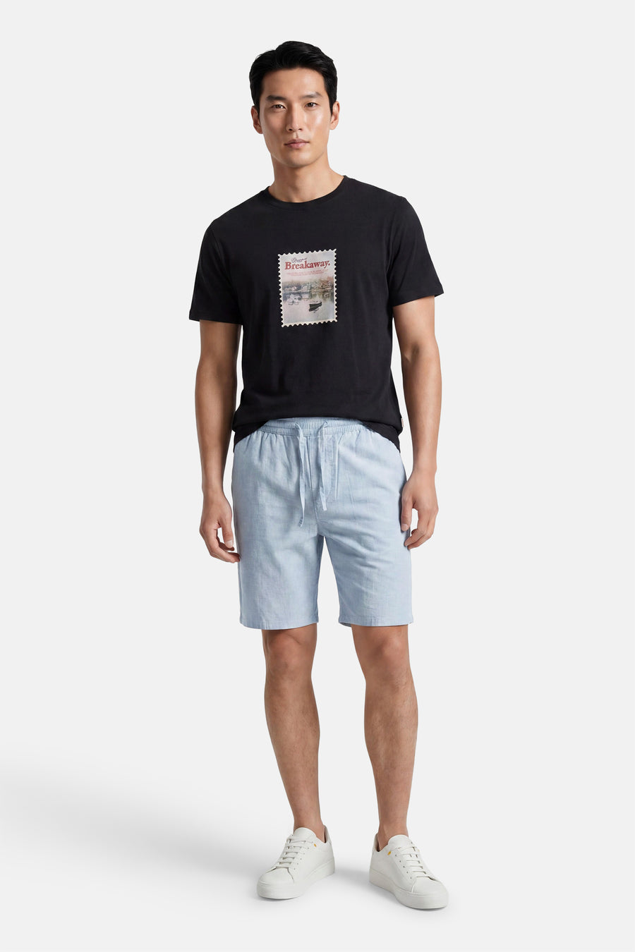 Lichtblauwe short van ONLY & SONS® met trekkoord, gedragen door een man met een zwart T-shirt en witte sneakers.