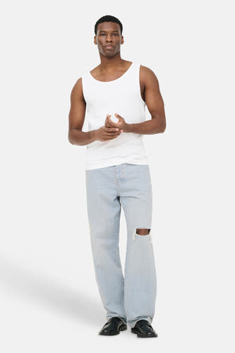 Lichtblauwe wide-leg jeans van ONLY & SONS met scheur op de knie, gedragen door een man.
