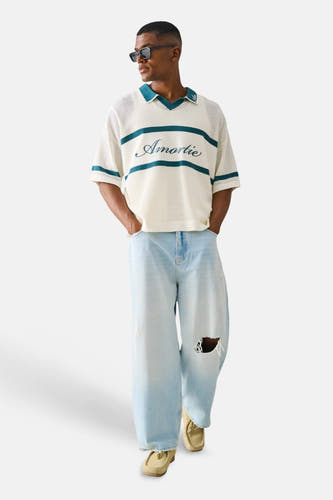 Lichtblauwe wide-leg jeans van ONLY & SONS® met scheuren, gestyled met een crème polo en lichte mocassins.