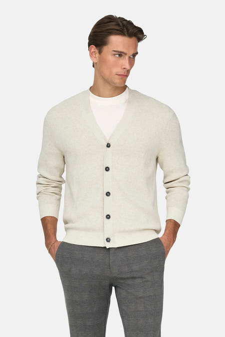 Gilet écru de ONLY & SONS®, porté sur un T-shirt blanc avec un pantalon gris et des loafers noirs.